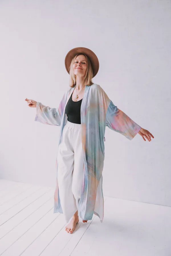 Frau im fließenden Kimono mit ausgebreiteten Armen im Studio