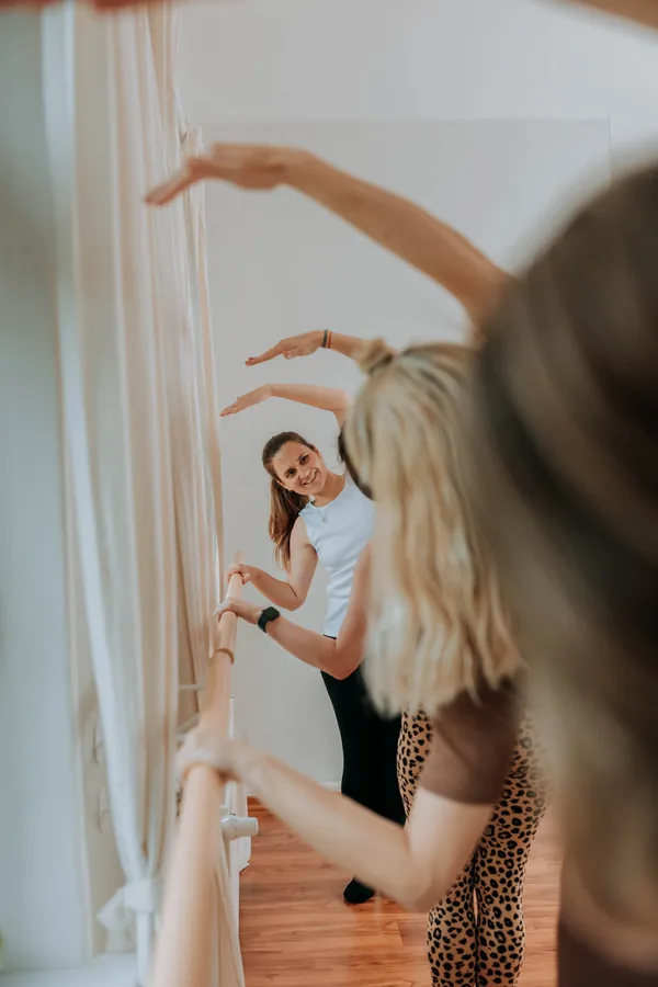 Zwei Frauen an der Ballettstange in einem hellen Studio